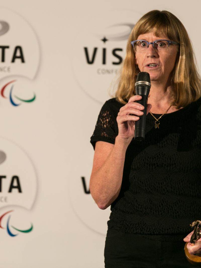 Woman on a stage, giving a speech