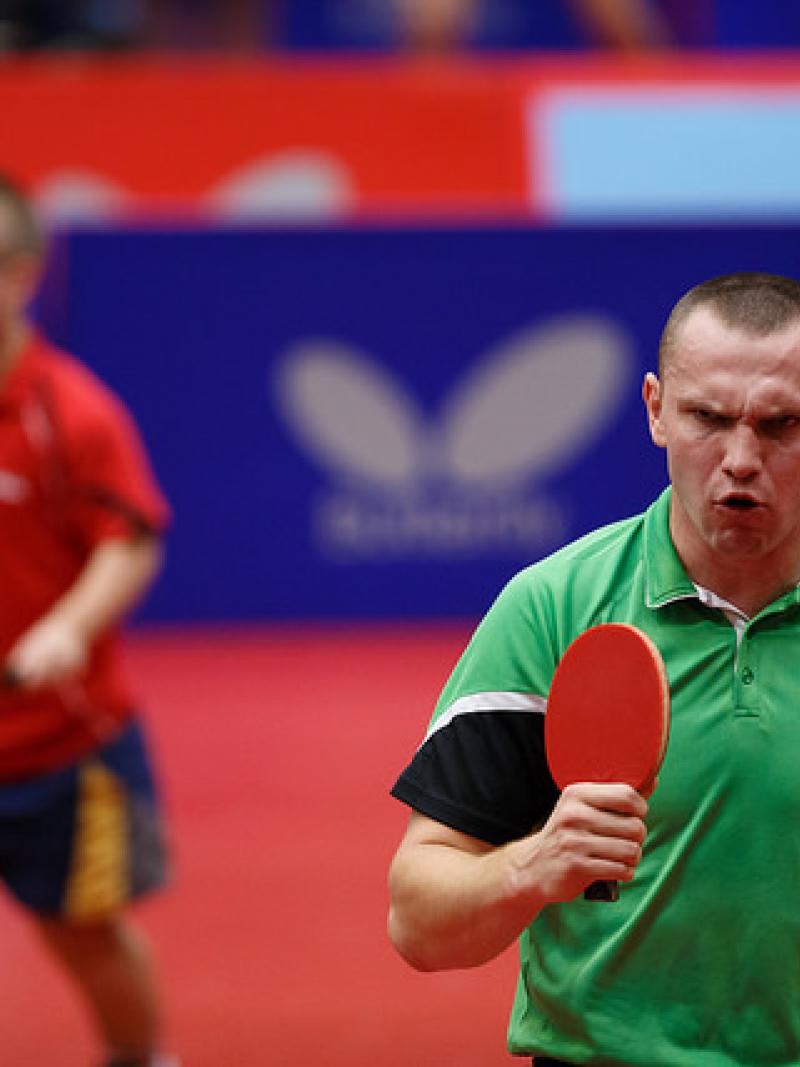 Man with table tennis racket celebrates