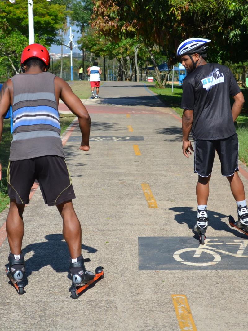 Two men on rollerblades on a bicycle way