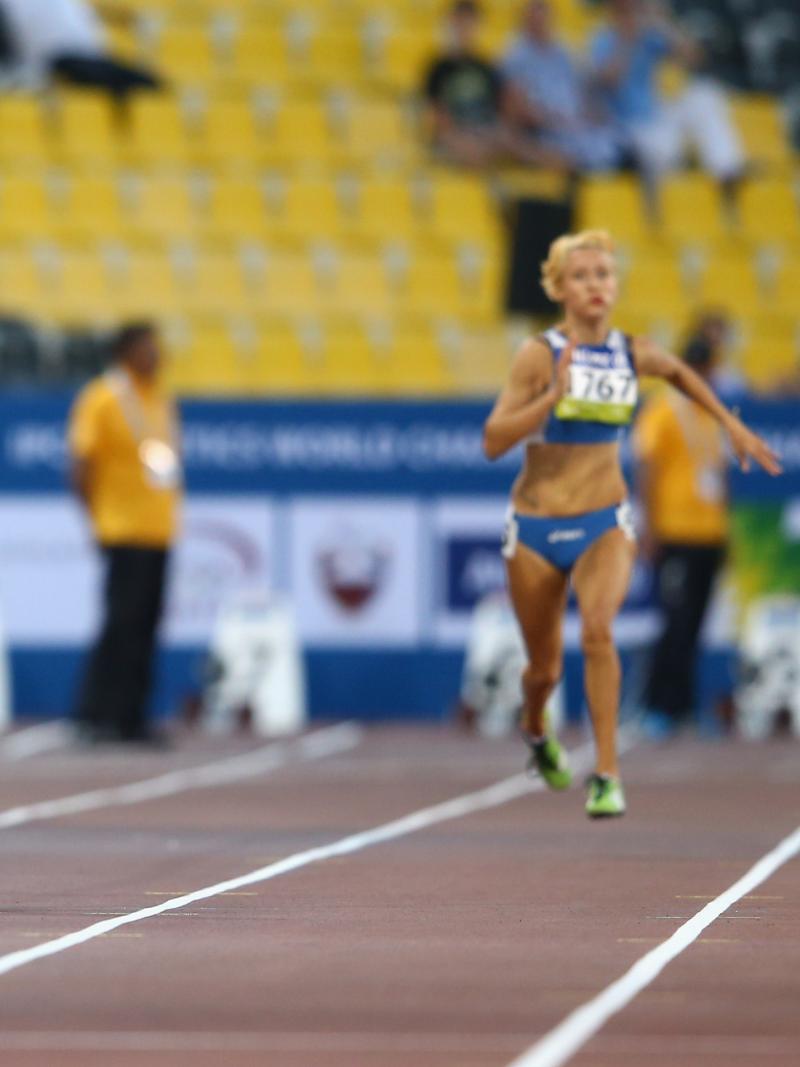Two young women running on a track, head to head