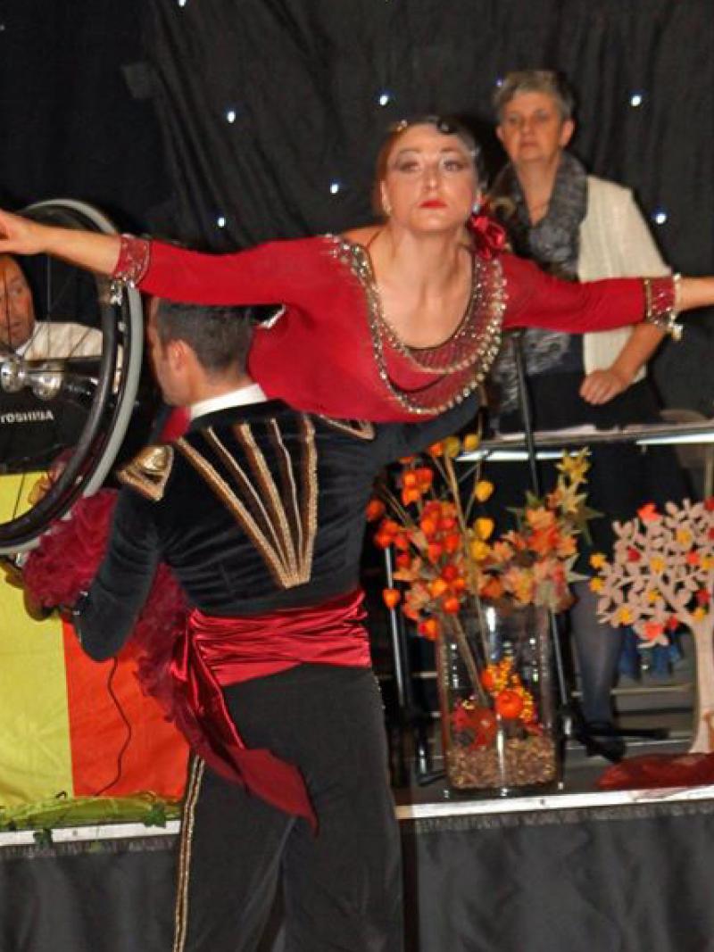 A wheelchair dancer is held aloft during a dance