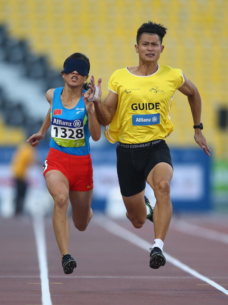 Blindefolded woman runs with guide