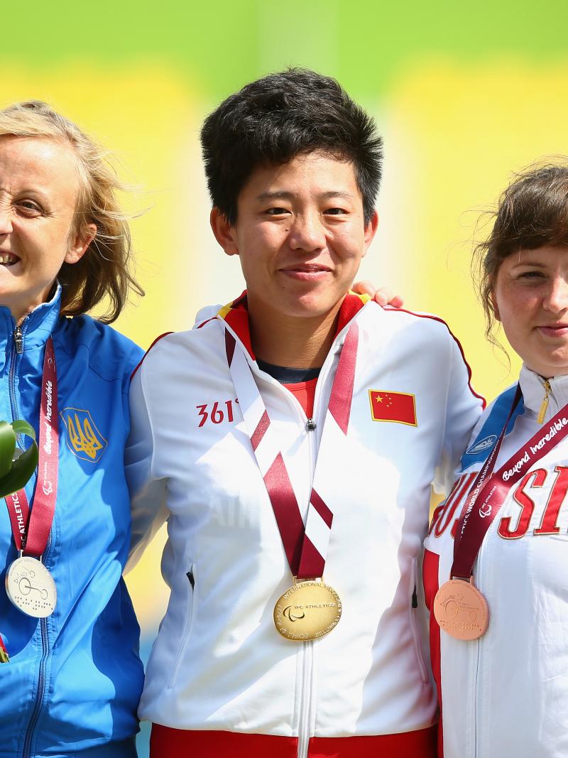 Podium of three women showing their medals