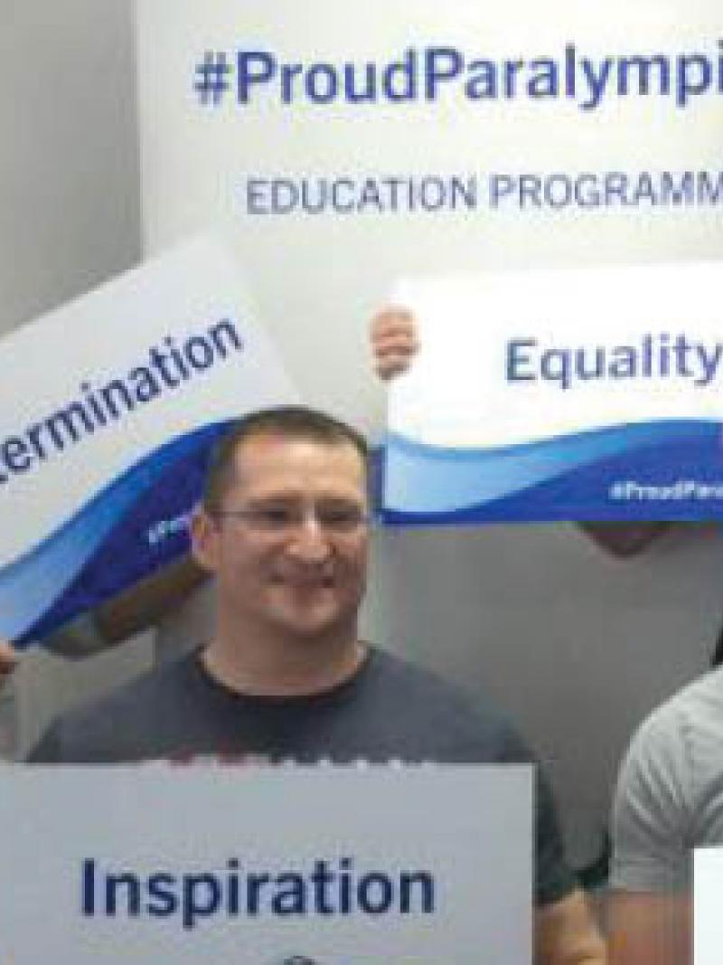 Group shot of young people holding signs with words on it (inspiration, courage)