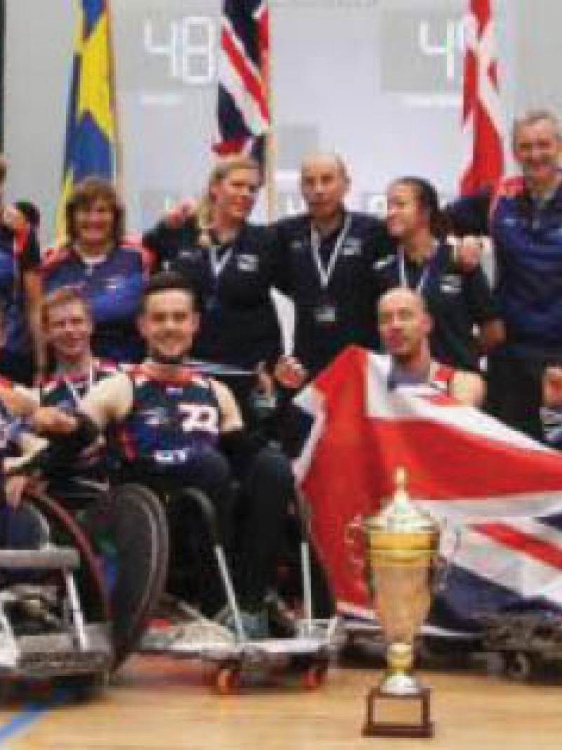 Group picture of people in wheelchairs, showing a cup