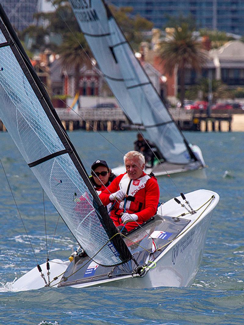 Two sailors in a boat on the water, wearinf red jackets