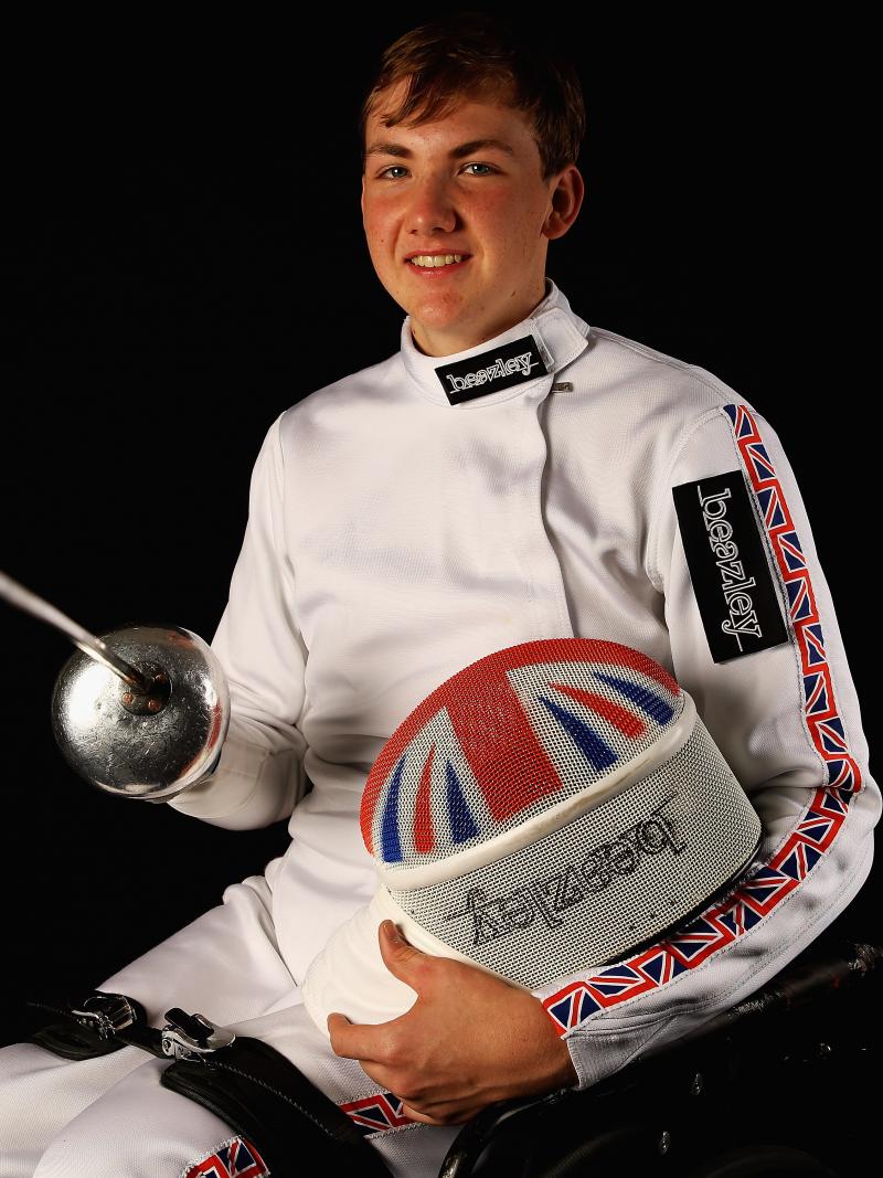 Man in wheelchair with a foil smiling to the camera