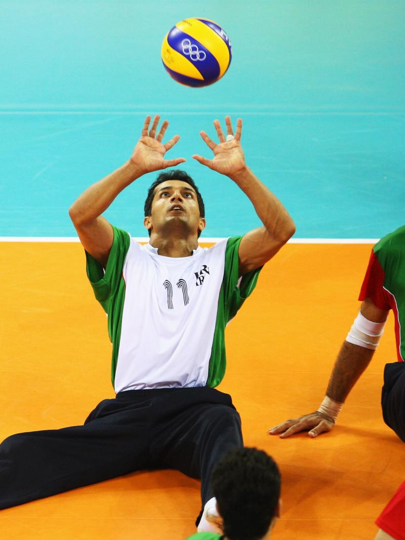 Man hits a volleyball in the air 