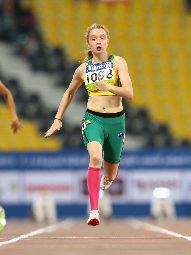 three females running, one wearing green, one blue and one red