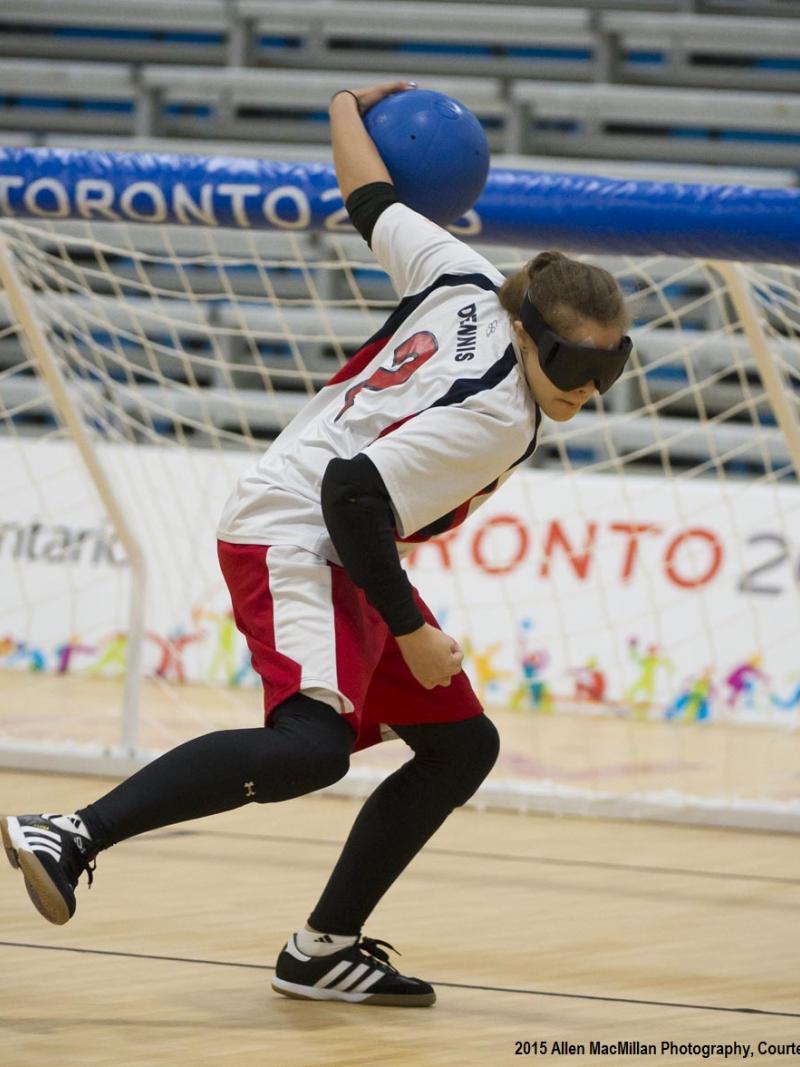 a female wearing white, black and red competing in goalball