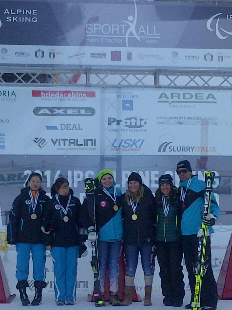 Podium of six people in front of a branded wall