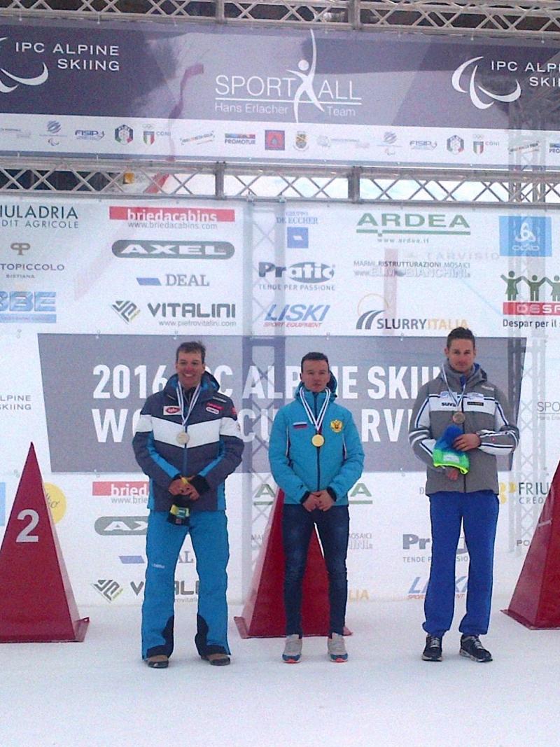 Podium with three men smiling.