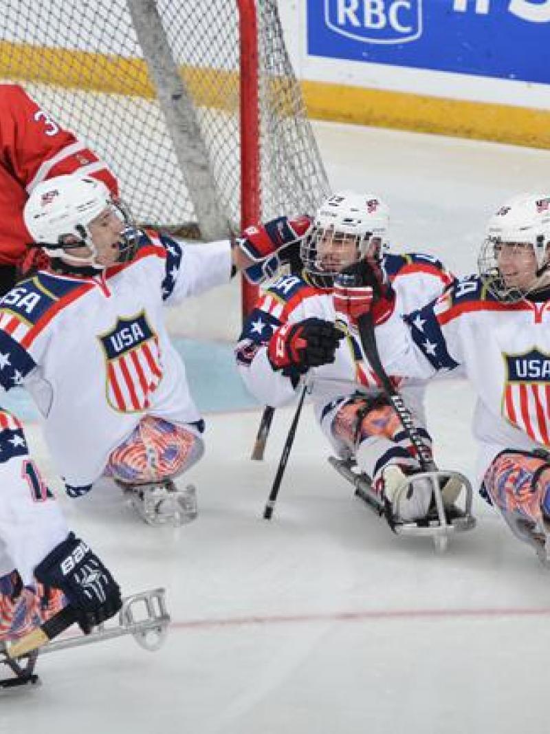 US ice sledge hockey players celebrate after a goal