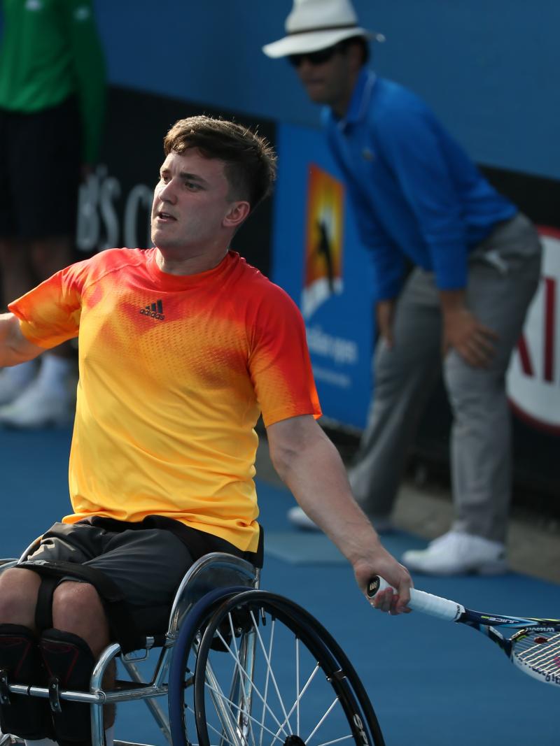 Man in wheelchair playing tennis