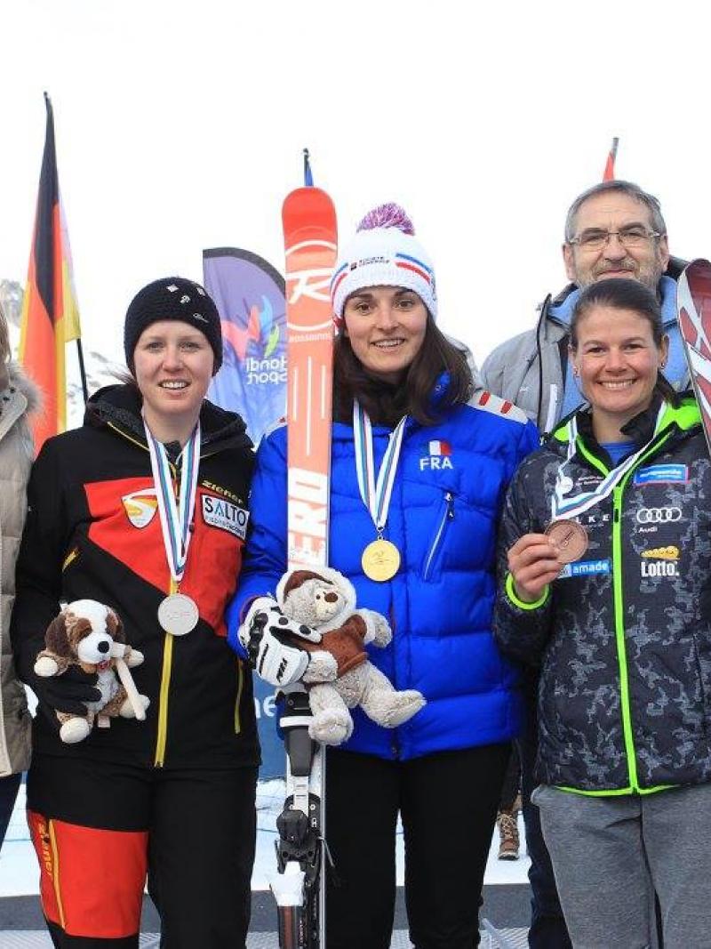 Three women alpine skiers pose with their medals from a World Cup