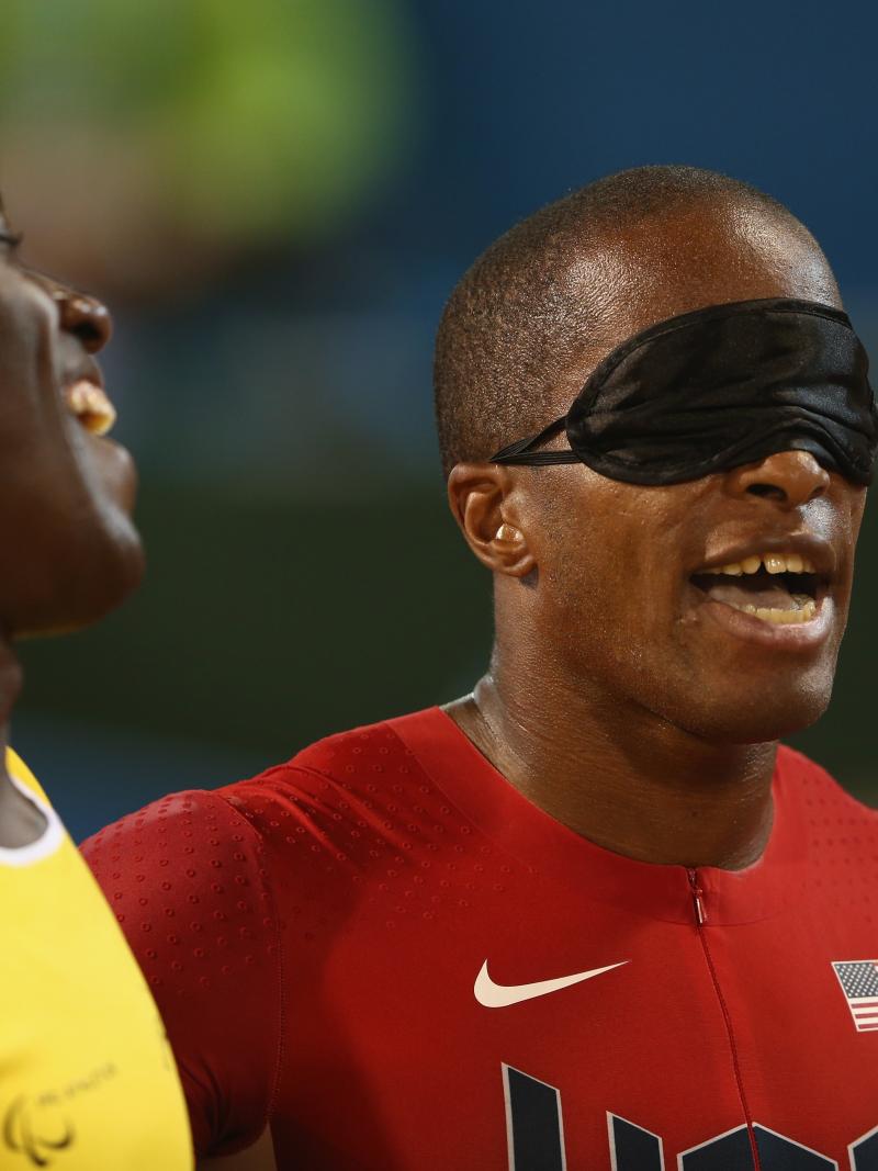 Two men, one blindfolded, laughing