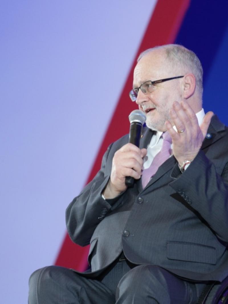 Man in wheelchair speaking on a stage