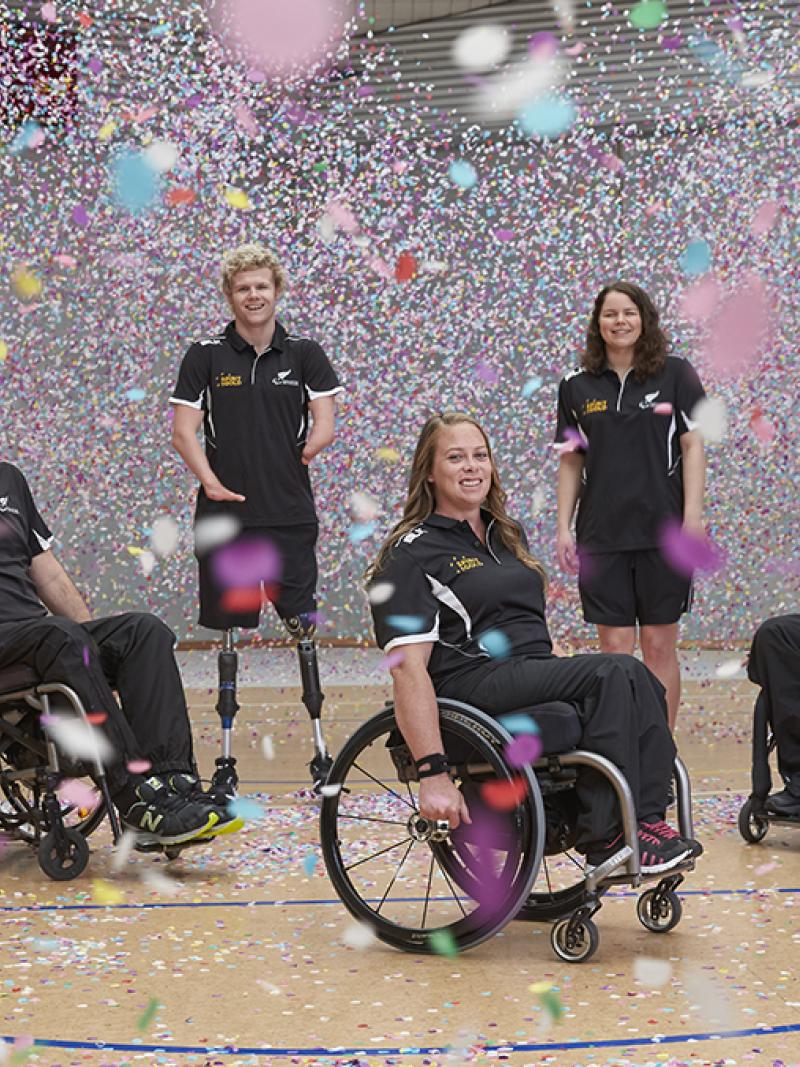 Six people standing and in wheelchairs