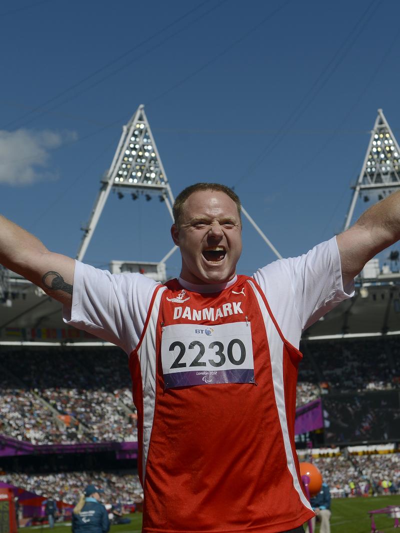 Man in stadium waves his arms in the air, celebrates