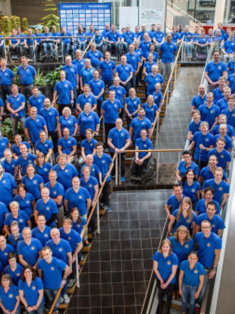 Group picture of many people in blue shirts, shot from above