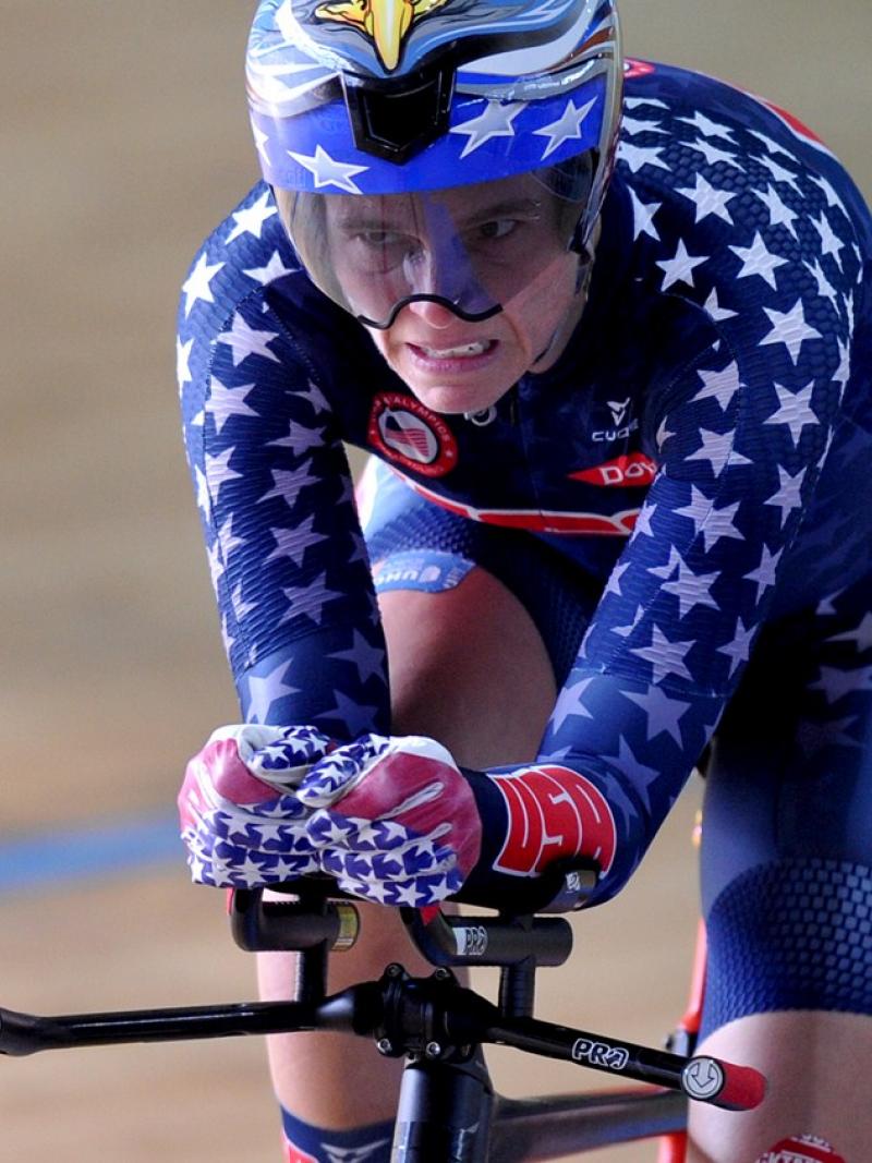 Male cyclists pedals on track velodrome.
