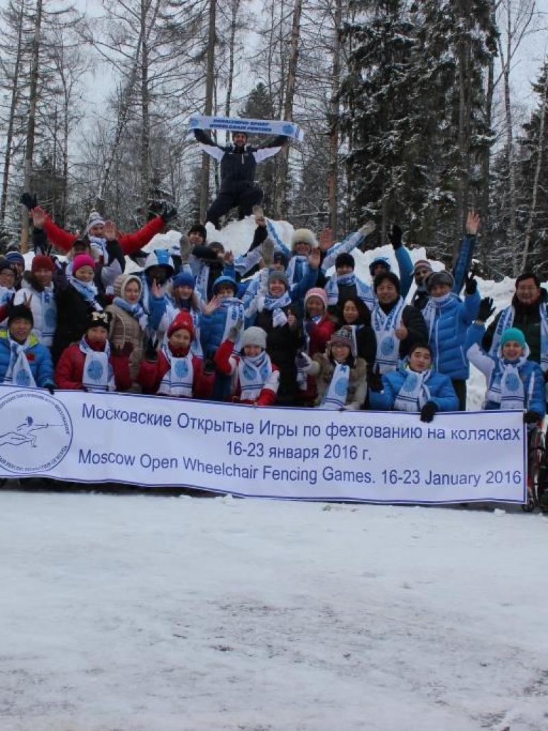 Group picture of people in wheelchairs and standing people in the snow