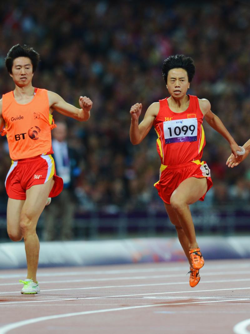 China's Guohua Zhou and her guide Jie Lie cross the line first to win gold ahead of teammates and bronze medalists Daqing Zhou of China and her guide Hui Zhang in the women's 100m T12 Final at the London 2012 Paralympic Games.
