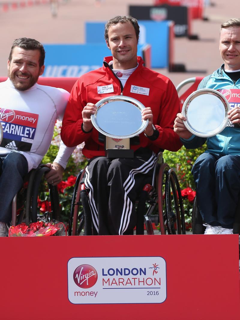 The podium finishers at the 2016 Virgin Money London Marathon - winner Switzerland's Marcel Hug of Switzerland (C), second place Australia's Kurt Fearnley (L) and third place Great Britain's David Weir.