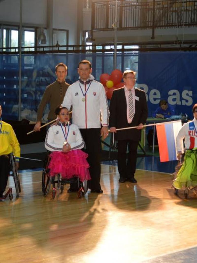 Athletes in wheelchairs and standing pose for a group photo
