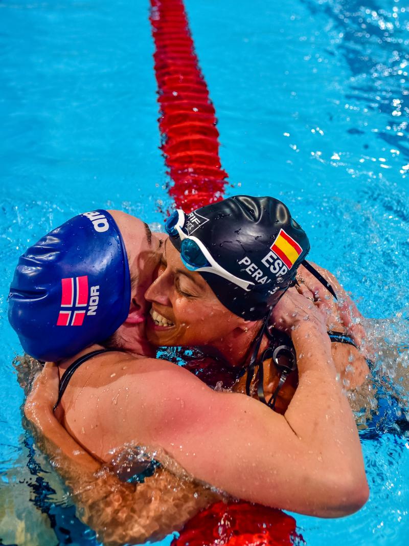 Two swimmers hugging after a race