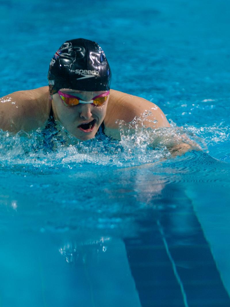 Female swimmer takes a breath between strokes