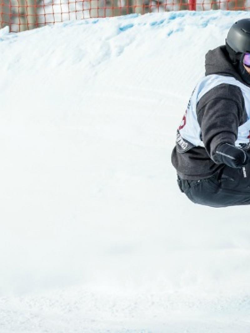 Male snowboarder going down a slope