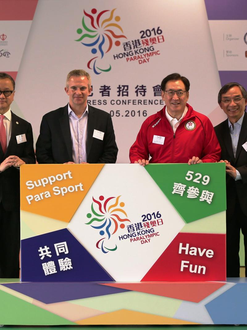Four people pose with a poster