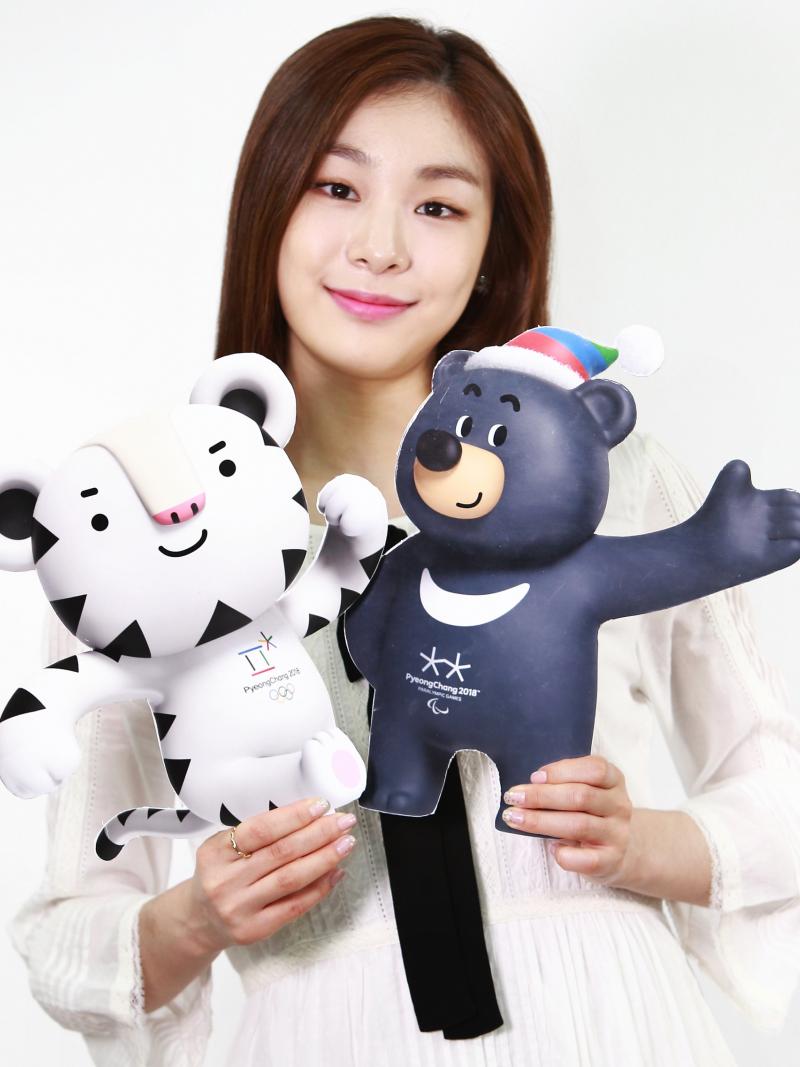 Asiatic woman holding two images of tiger and bear mascot