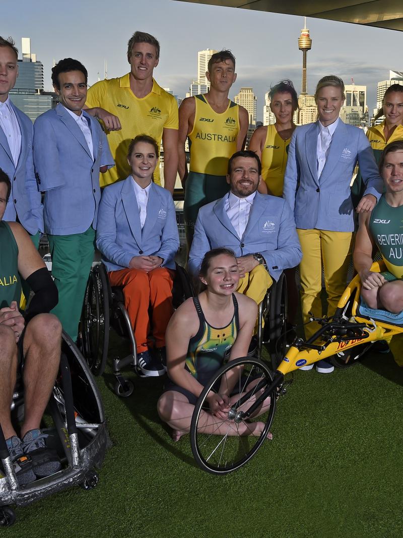 A group of 12 paralympians wearing the new green and yellow uniforms. 