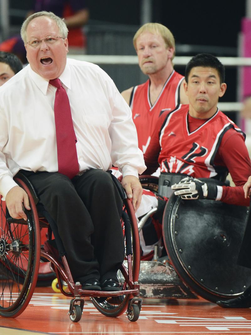 Wheelchair rugby coach in wheelchair yells instructions 