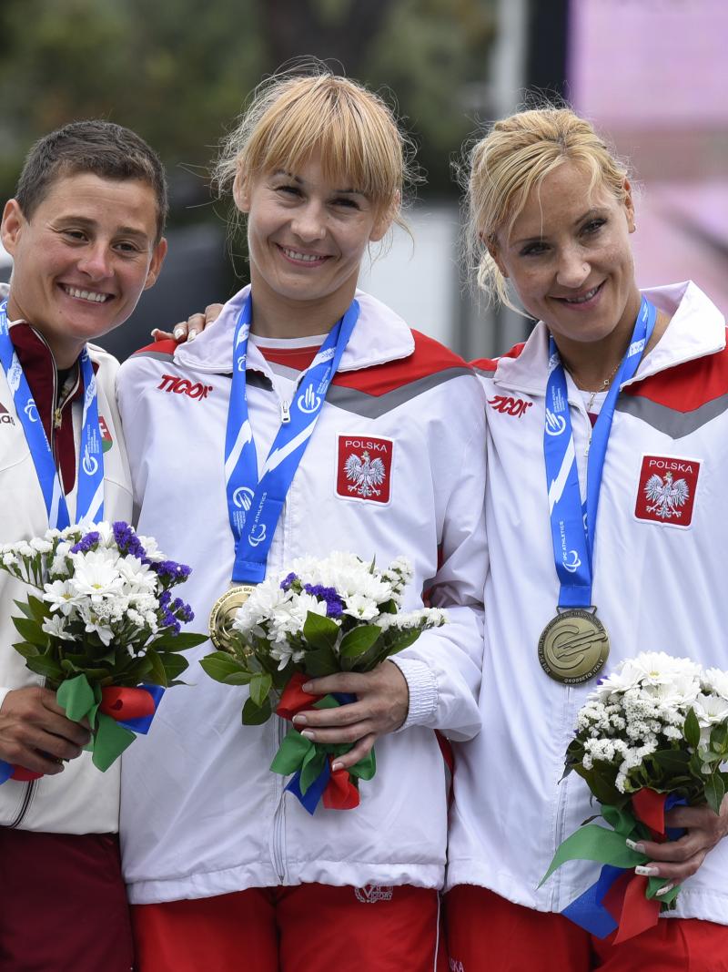Podium with 3 women holding flowers