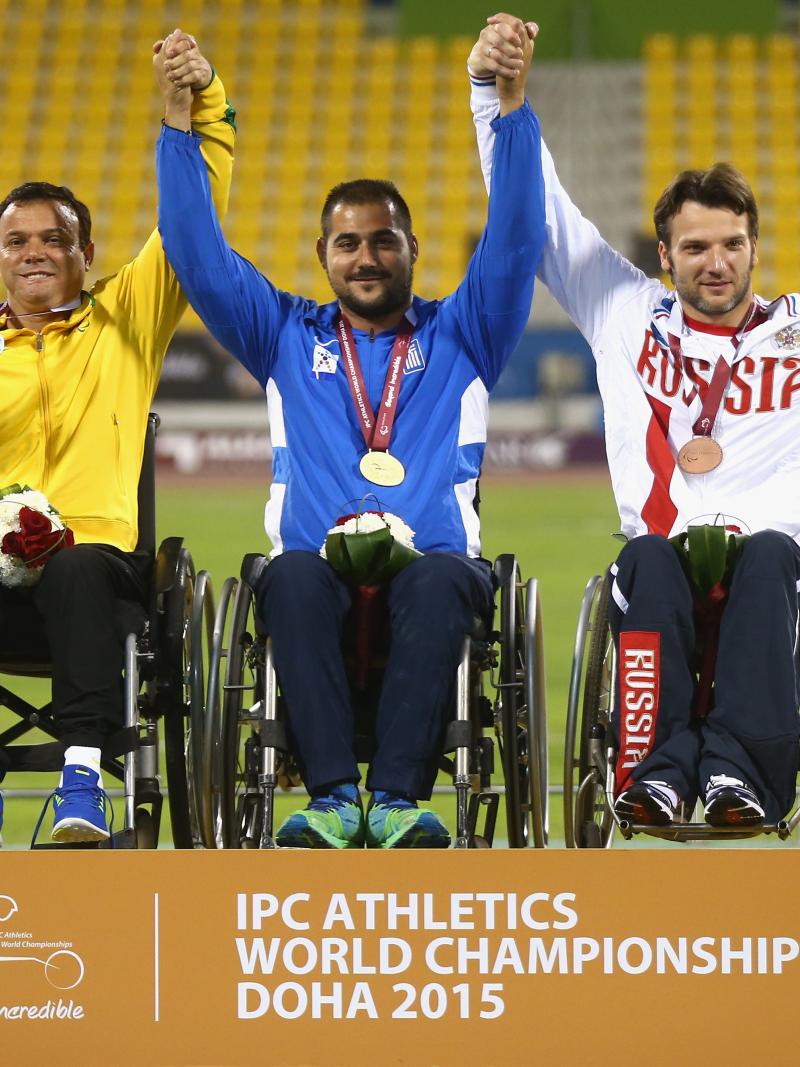 Podium with three men in wheelchairs, celebrating