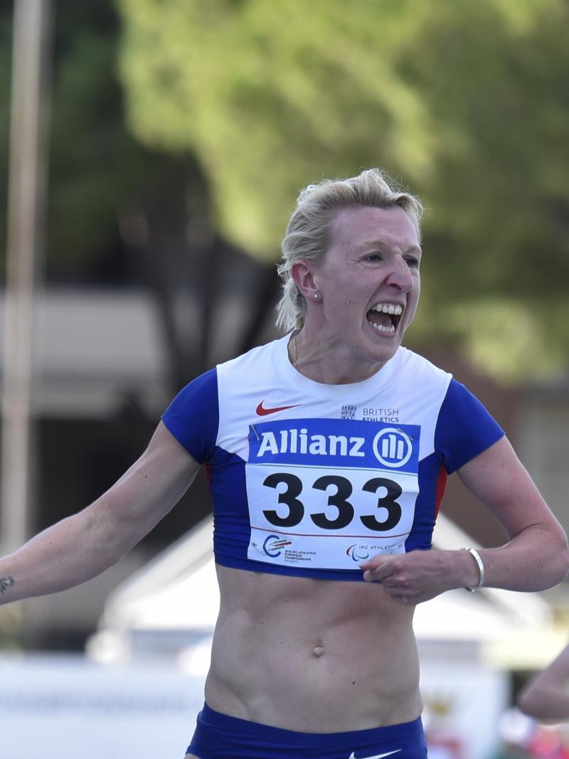 Woman in running shirt crossing the finish 