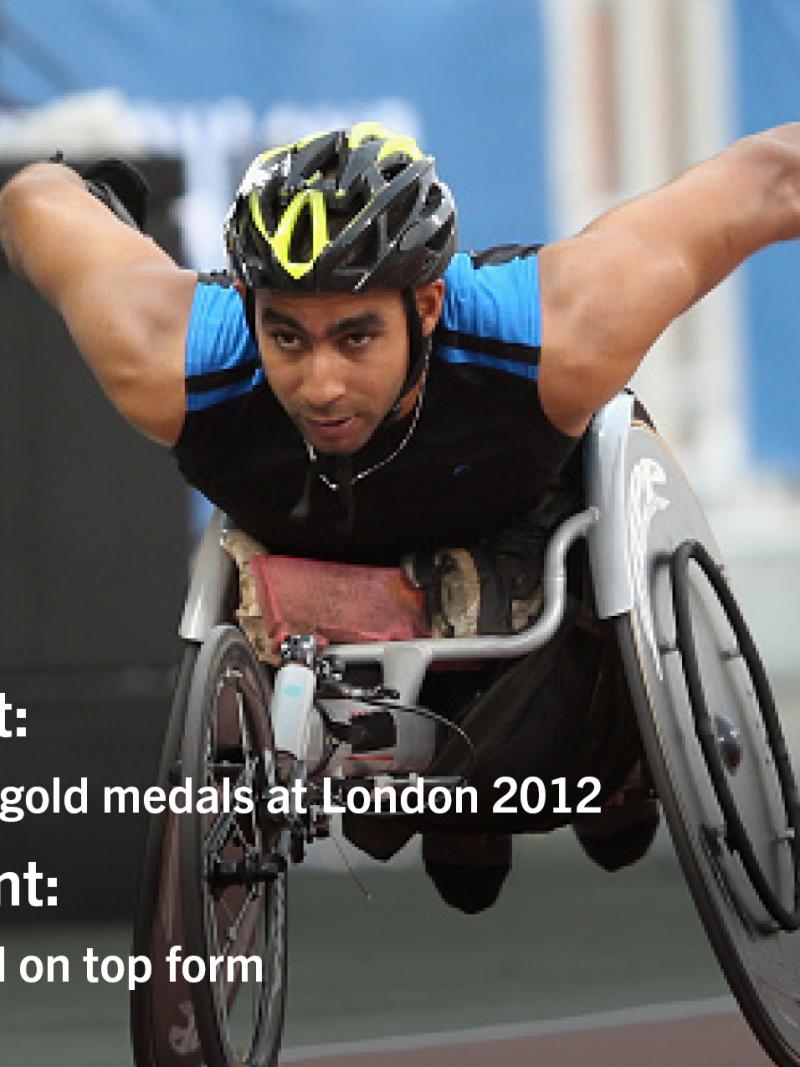 Man with helmet racing in a wheelchair