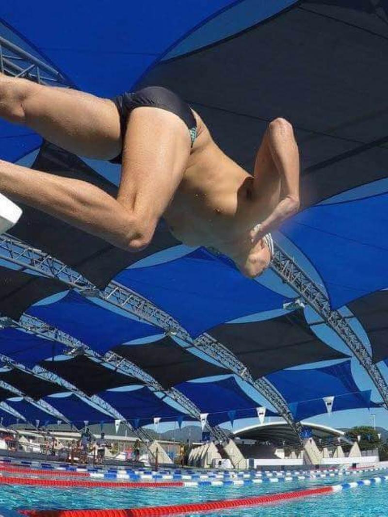 Swimmer jumping from the block into the water