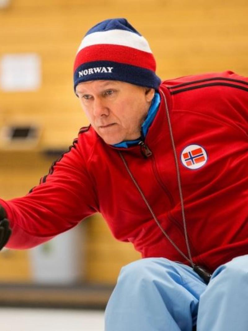 Man in a wheelchair doing curling