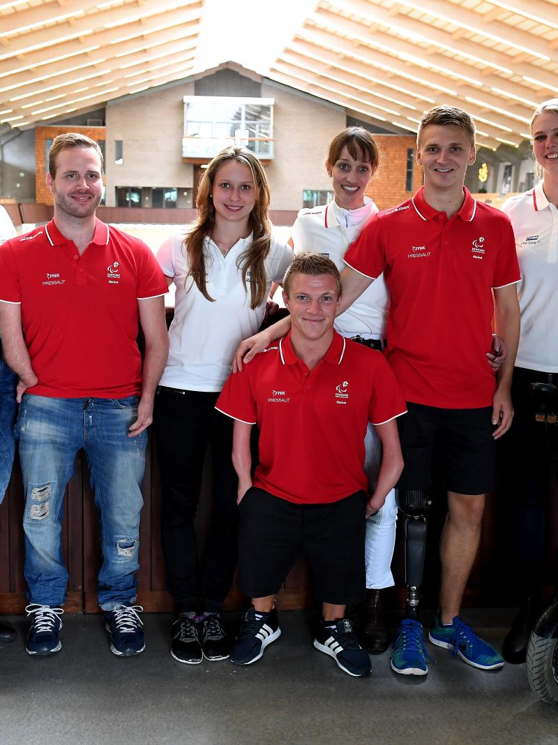 Fifteen Danish Para athletes pose for a photo wearing the red and white Danish colours.