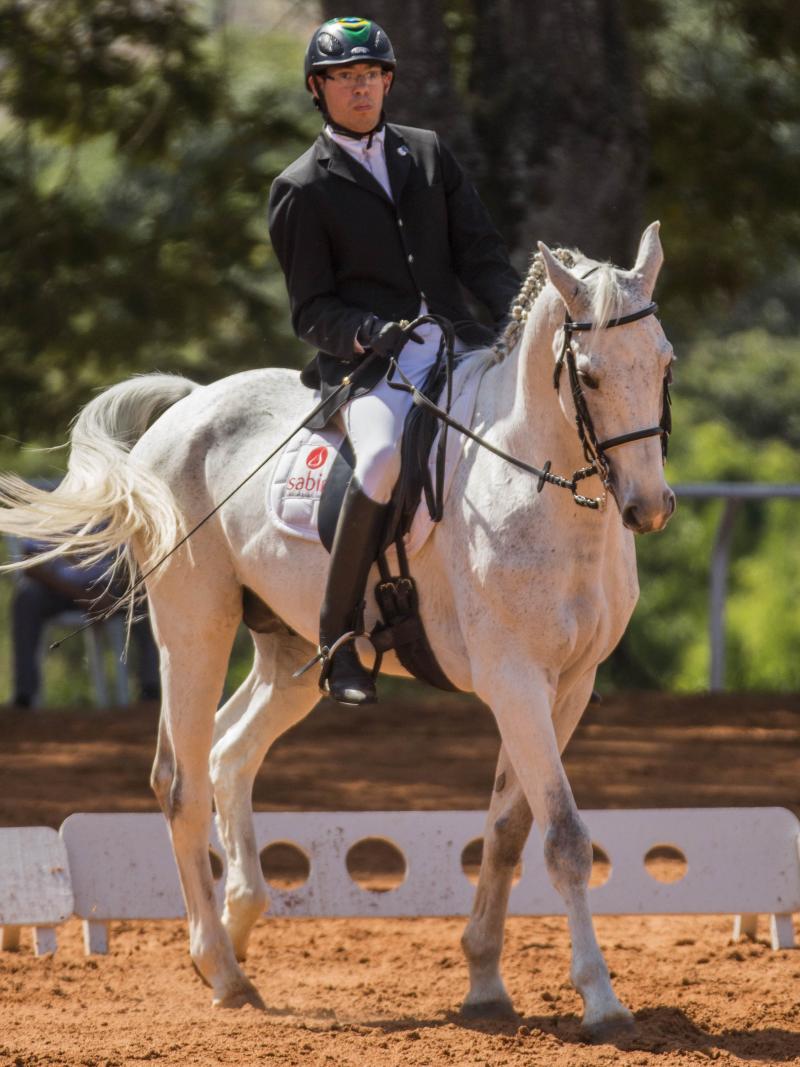 Man ridings on a white horse.