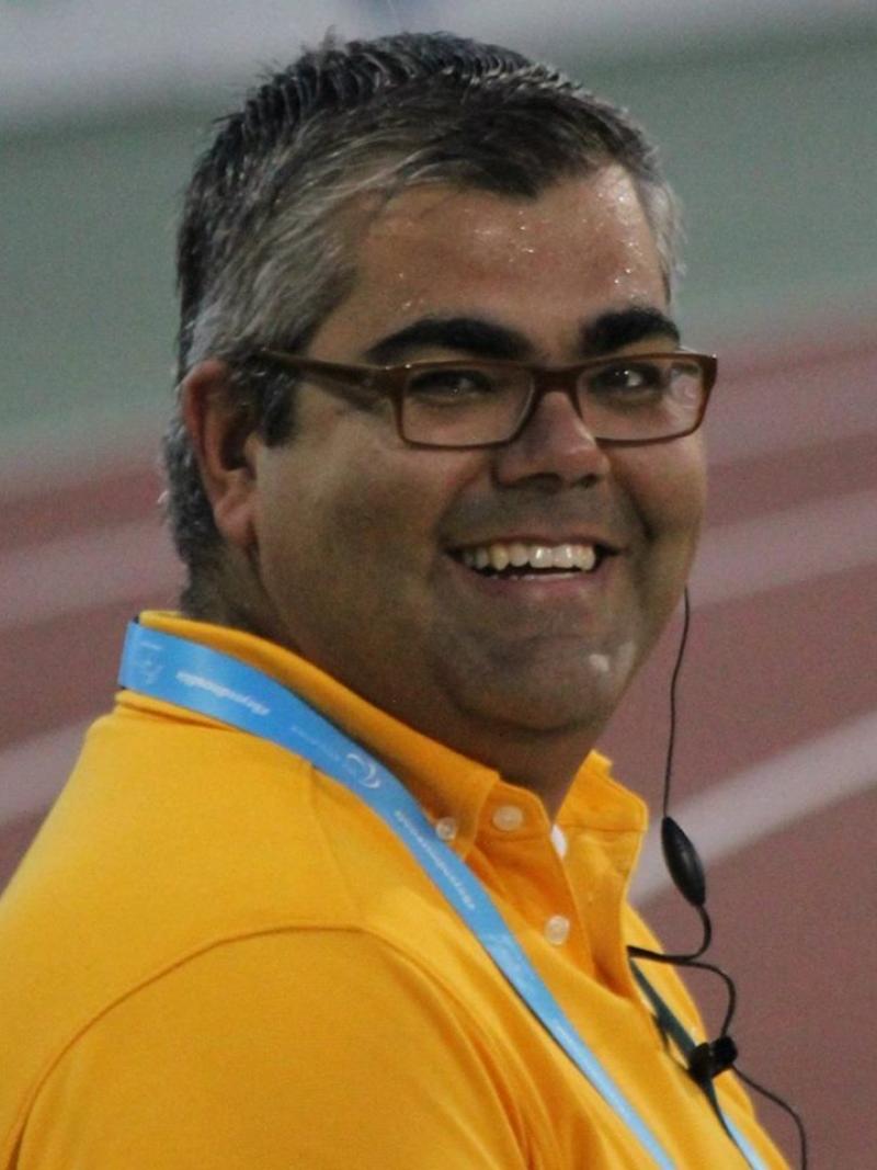 Portrait photo of man, smiling in yellow shirt