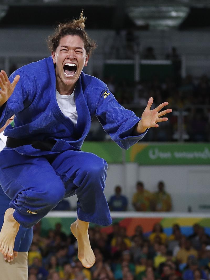 a female Para judoka jumps in the air in celebration