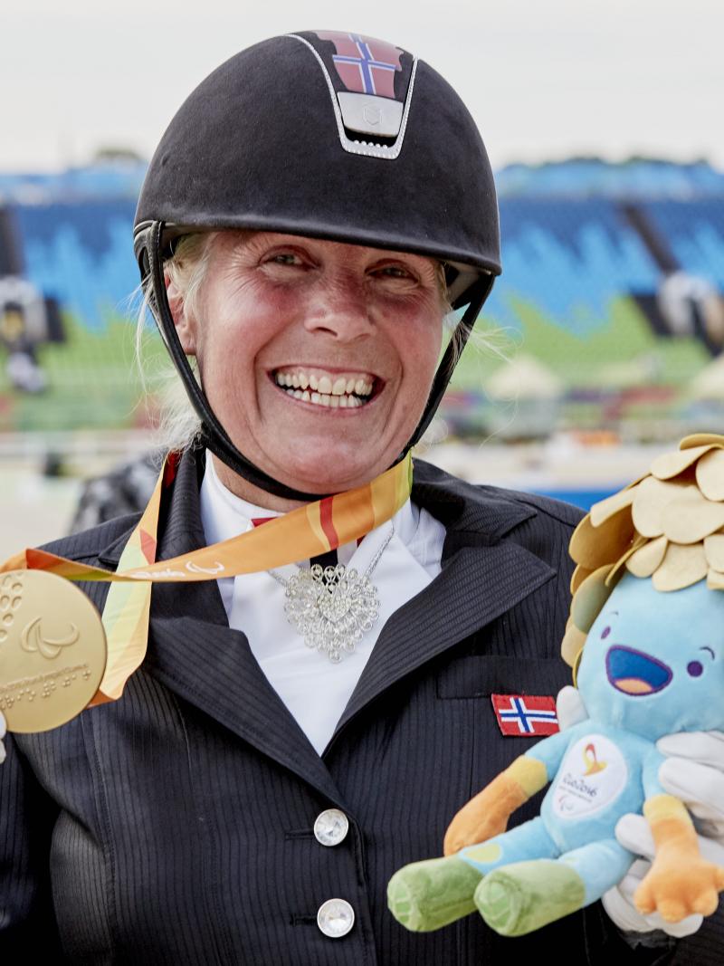 A dressage rider celebrating her medal.