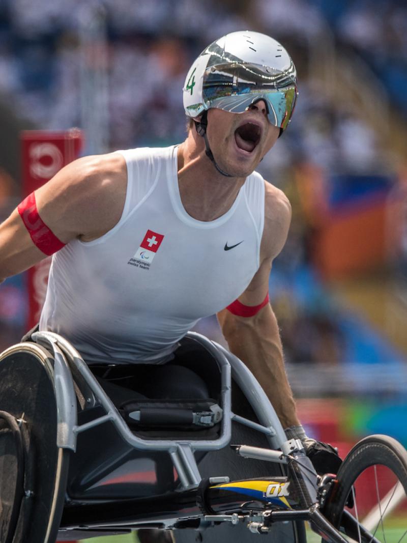 A wheelchair racer celebrates winning gold