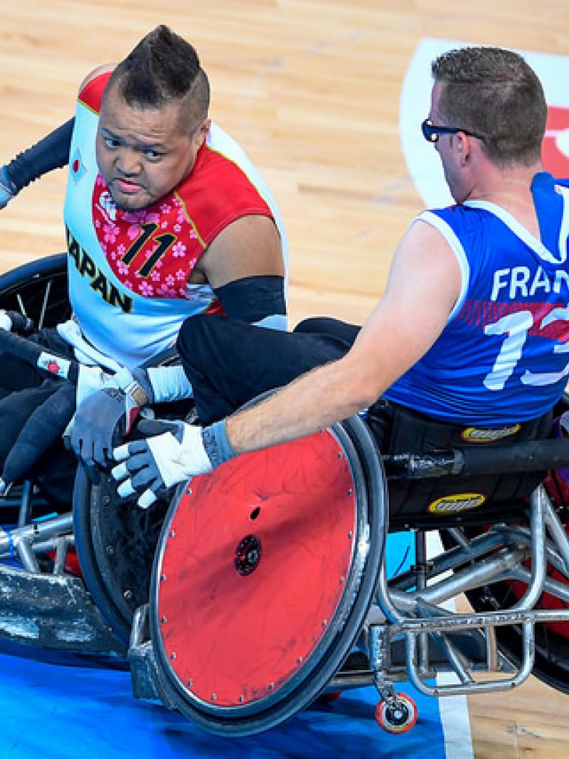 Two wheelchair rugby players crashing into each other