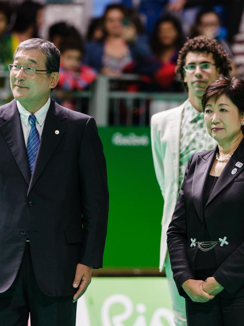 two officials stand together at a medal ceremony